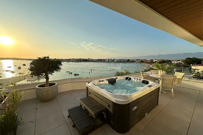 Jacuzzi na balkonu u apartmanu s pogledom na more u zalazak sunca